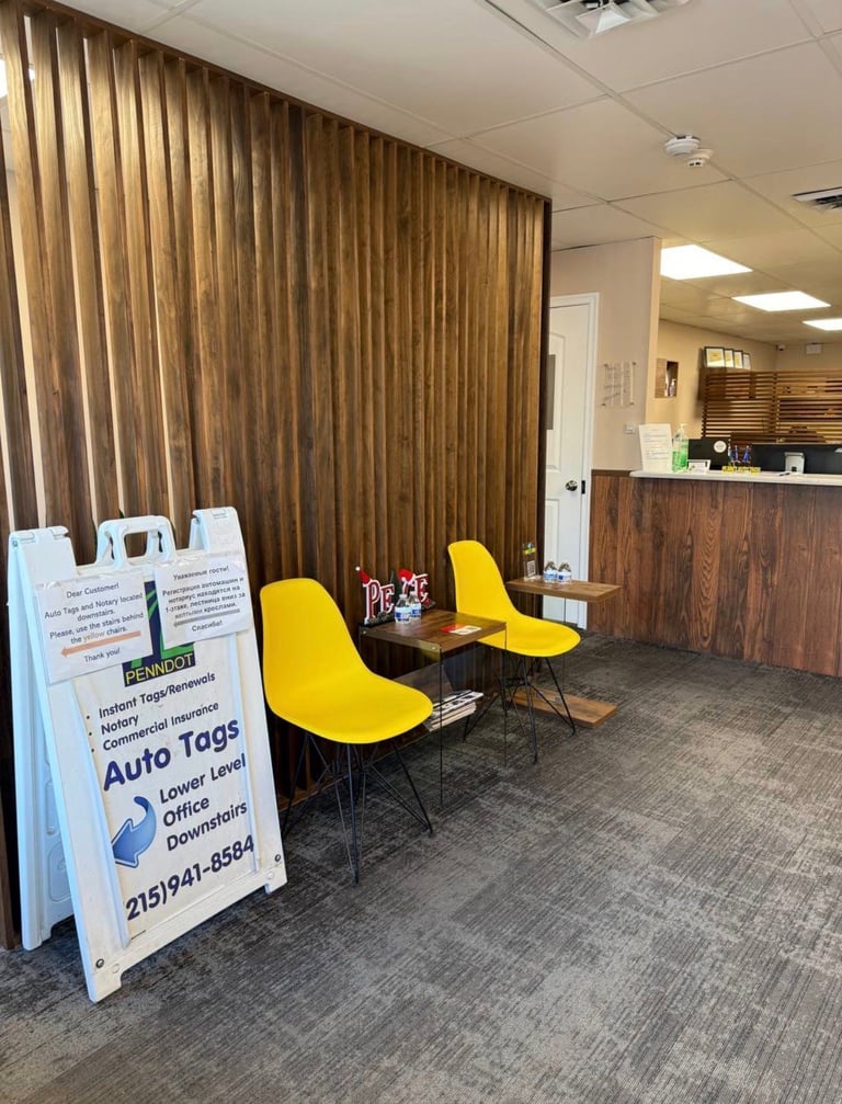 Interior of auto tags office with yellow chairs, brown wood backdrop, and informational sign on gray carpet flooring